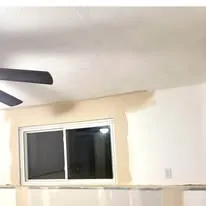 Finished and painted room with a ceiling fan and a large window