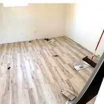 Luxury vinyl plank going down across a bedroom floor
