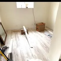 Vinyl plank flooring part way through installation with tools in the room