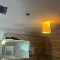 Ceiling drywall being finished in an open room