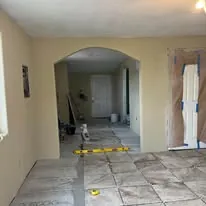 Large format tile floor through an arched entry