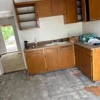 Tile floor laid through a kitchen with existing cabinets