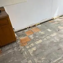 Dated tile floor before replacement, beside a base cabinet